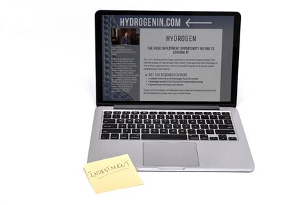MOSCOW, RUSSIA - DECEMBER 10, 2019: Laptop and yellow note with investment letters isolated on a white background.のeditorial素材