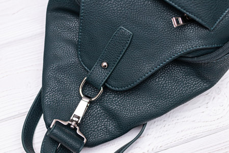Synthetic leather backpack on a wooden background.