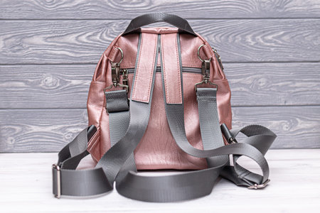 Synthetic leather backpack on a wooden background.