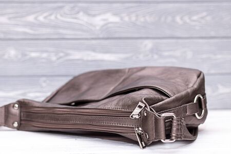 Fashion synthetic leather handbag on a wooden background.の写真素材
