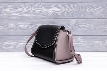 Fashion synthetic leather black handbag on a wooden background. Eco leather.の写真素材