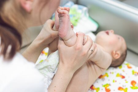 Baby massage. Mother is massaging the baby.の写真素材