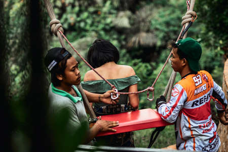 BALI, INDONESIA - MAY 16, 2018: Young woman swings in the jungle of Bali island. Rainforest of Indonesia. Travel concept.のeditorial素材