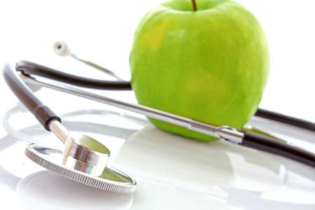Stethoscope and green apple on white backgroundの写真素材