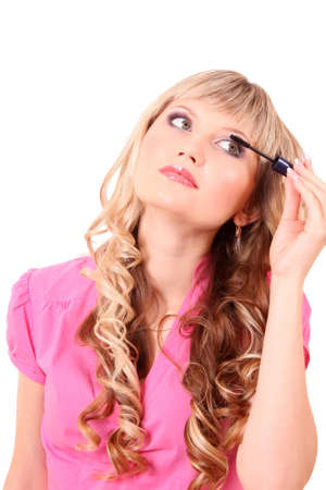 Beautiful young blonde woman applying mascara on her eyelashesの写真素材