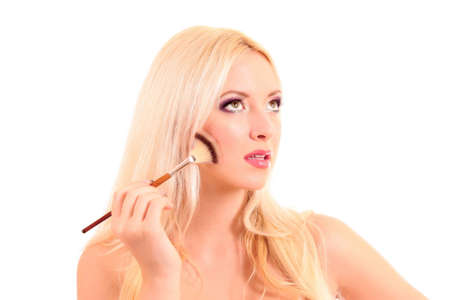 Young woman applying eye shadow, isolated on whiteの写真素材