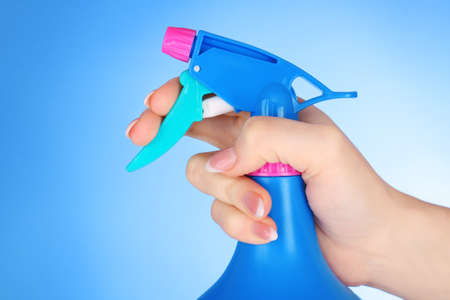Hands with spray  on blue backgroundの写真素材