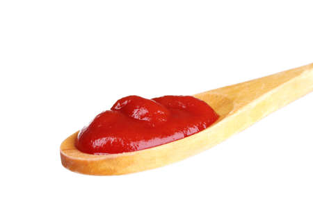 Tasty ketchup in wooden spoon isolated on whiteの写真素材