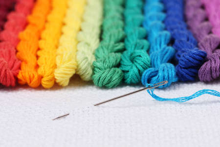 sewing threads for embroidery and  needle with a thread on white cottonの写真素材