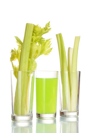 fresh green celery in a glass and juice isolated on whiteの写真素材
