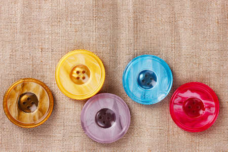 Bright sewing buttons on gray fabric Bright sewing buttons on gray fabric