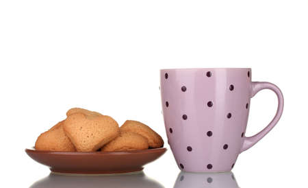 Pink cup and heart-shaped cookies on brown plate isolated on whiteの写真素材