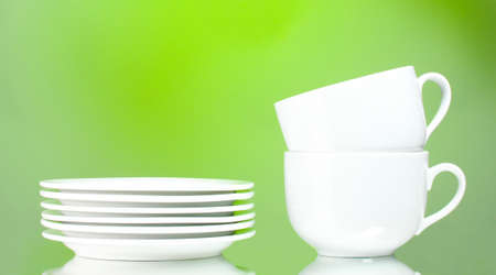 Clean plates and cups on green backgroundの写真素材