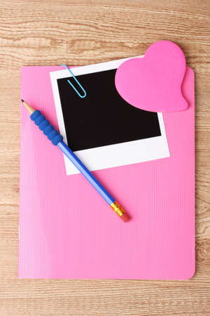 Photo paper and pink notebook on wooden backgroundの写真素材
