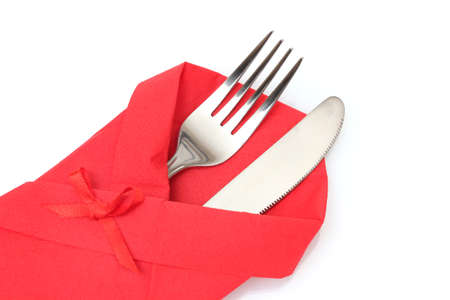 Fork and knife in a red cloth with a bow isolated on whiteの写真素材