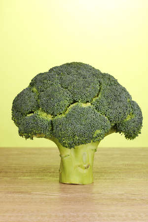 Fresh broccoli on wooden table on green backgroundの写真素材