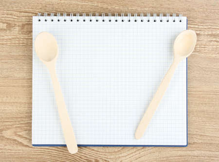Open cookbook and kitchenware on wooden backgroundの写真素材