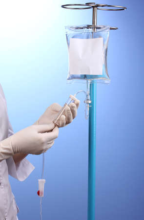 Nurse doing infusion on blue backgroundの写真素材