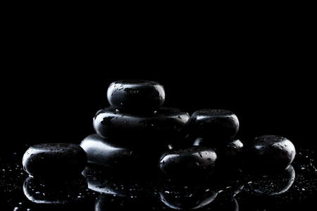 Spa stones with drops on black backgroundの写真素材
