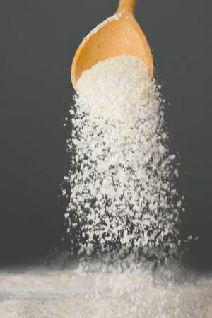 Wooden spoon with sea salt on a gray background close-upの写真素材