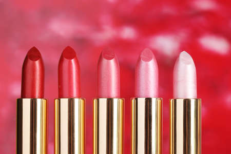 beautiful lipsticks on red backgroundの写真素材