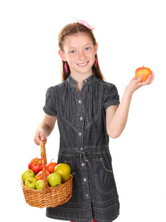 beautiful little girl holding basket of apples isolated on whiteの写真素材