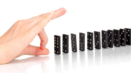 Hand pushing dominoes isolated on whiteの写真素材