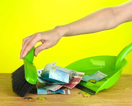Sweeps money in the shovel on colorful background close-upの写真素材