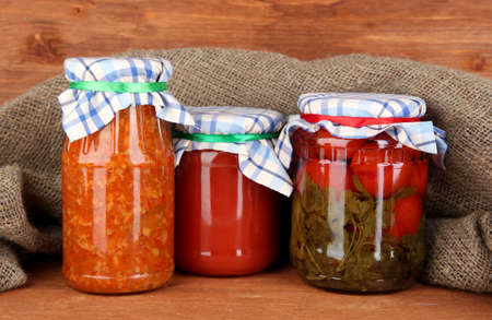 Jars with canned vegetables on wooden background close-upの写真素材