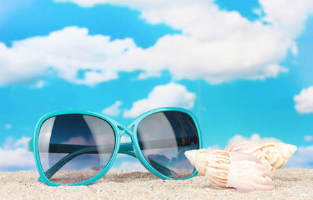 Elegant women's sunglasses with shell at the beachの写真素材