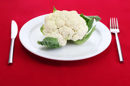 Fresh cauliflower on plate, knife and forkの写真素材