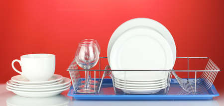 clean dishes on stand on red backgroundの写真素材