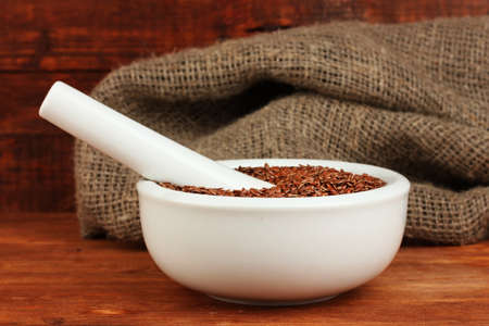 Mortar with flax seeds on wooden background close-upの写真素材