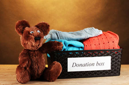 Donation box with clothing on brown background close-upの写真素材