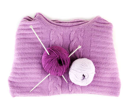 Purple sweater and a ball of wool isolated on whiteの写真素材