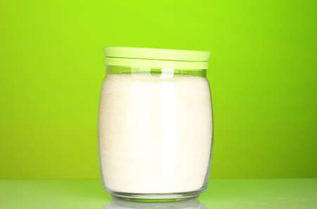 Jar with white crystal sugar on colorful backgroundの写真素材