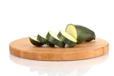 Sliced zucchini on chopping board isolated on whiteの写真素材