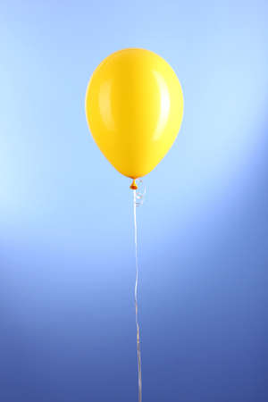 Yellow one balloon on blue backgroundの写真素材