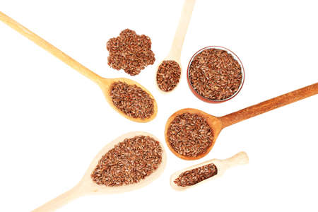 flax seeds in wooden spoons on white background close-upの写真素材