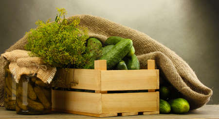 fresh cucumbers in wooden box, pickles and dill, on grey backgroundの写真素材
