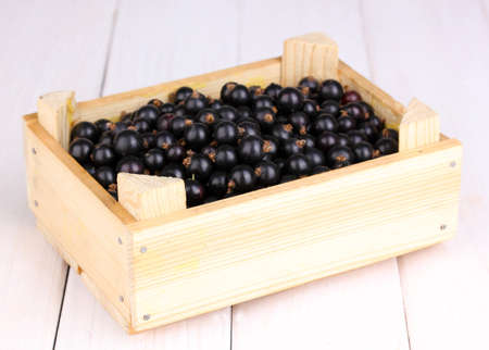 Black currant in crate on wooden backgroundの写真素材