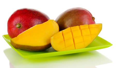 Ripe appetizing mango on green plate isolated on whiteの写真素材
