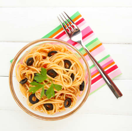 Italian spaghetti in glass bowl on wooden tableの写真素材