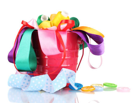 Color bucket with multicolor ribbons and thread isolated on whiteの写真素材