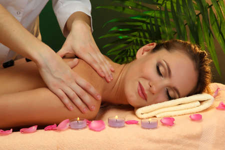 beautiful young woman in spa salon getting massage with spa stonesの写真素材