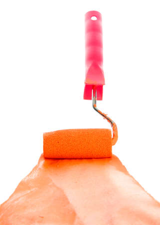roller with orange paint isolated on whiteの写真素材