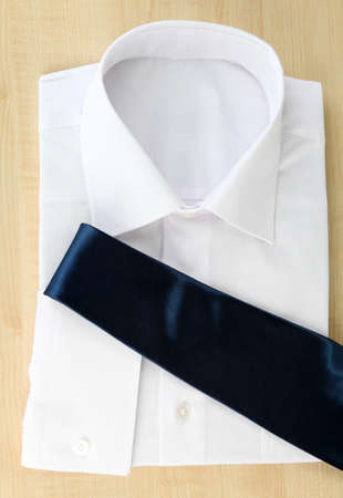 New white man's shirt with color tie on wooden backgroundの写真素材