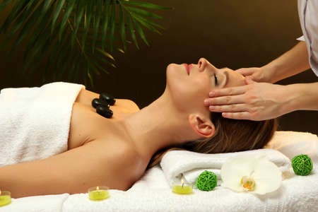 Portrait of beautiful woman with spa stones taking head massageの写真素材
