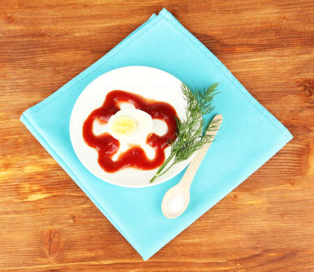Boiled egg with ketchup on wooden backgroundの写真素材