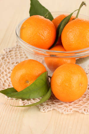 Sweet tangerines with leaves, on wooden backgroundの写真素材